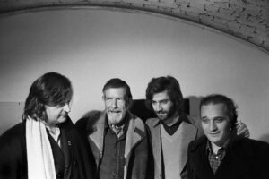 Foto: da sin. Gianni Sassi, John Cage, Mino Bertoldo, Walter Marchetti all'Out Off in occasione della conferenza stampa per ilo concerto di John Cage al Teatro Lirico © Teatro Out Off